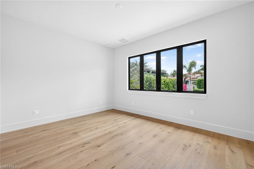 16736 Lucarno Way Naples, FL 34110 - Photo 21 of 49 Bedroom 2 room featuring light wood floors and large window for lots of natural light