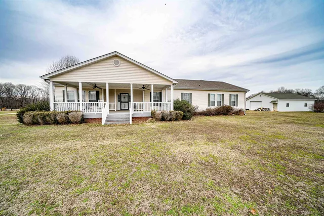 a front view of a house with a yard and trees
