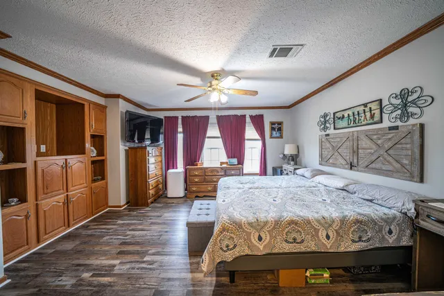 a bed sitting in a spacious bedroom next to a window