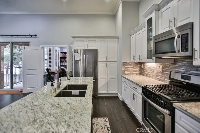 a kitchen with stainless steel appliances granite countertop a stove refrigerator and microwave