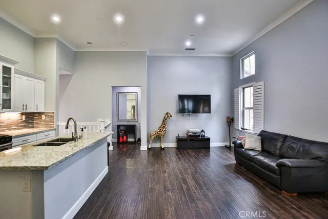 a living room with granite countertop furniture and a flat screen tv
