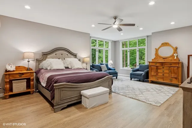 a spacious bedroom with a bed a mirror and a large window