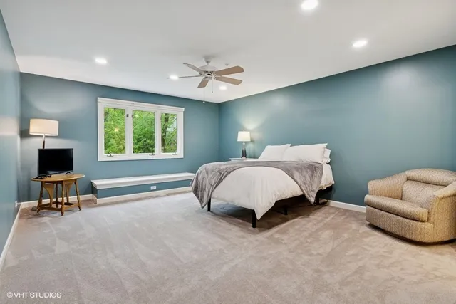 a spacious bedroom with a bed a couch and a window