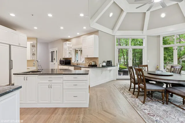 a kitchen with granite countertop white cabinets and chairs