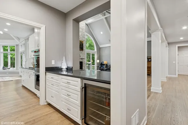 a view of a hallway with wooden floor windows and a living room