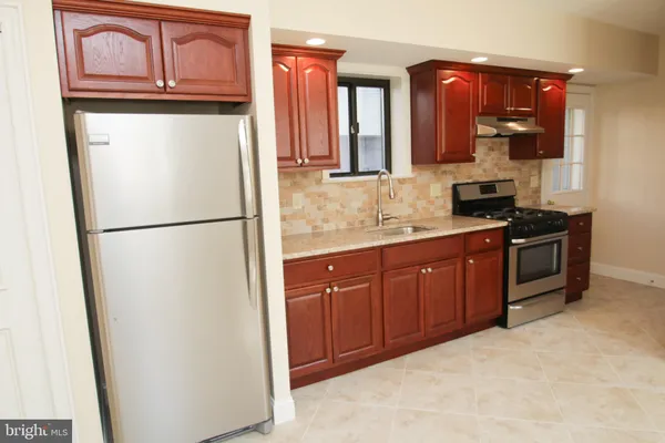 a kitchen with stainless steel appliances granite countertop a refrigerator a stove a sink and dishwasher