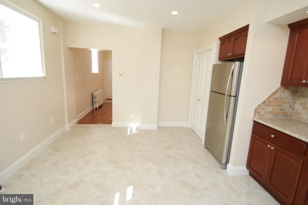 a view of kitchen with refrigerator cabinets and wooden floor