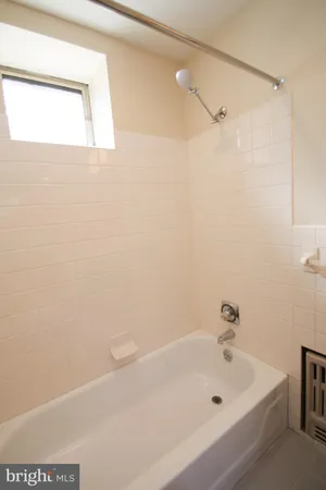 a white bath tub sitting next to a white sink and vanity