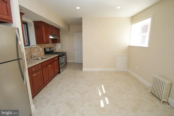 a kitchen with granite countertop a refrigerator and a stove top oven
