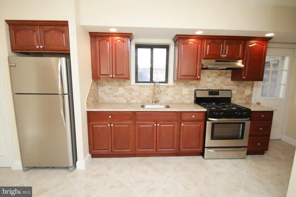 a kitchen with stainless steel appliances granite countertop a refrigerator a stove a sink and a microwave