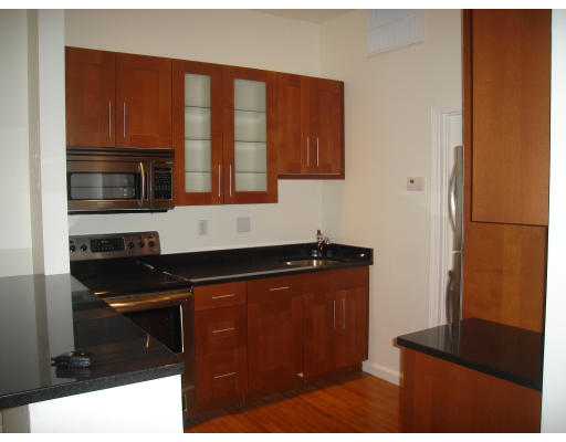 a kitchen with granite countertop stainless steel appliances a stove a microwave and a refrigerator