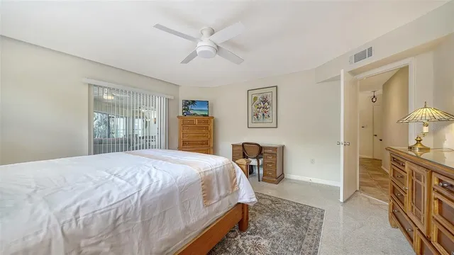 a bedroom with a bed and a dresser with wooden floor