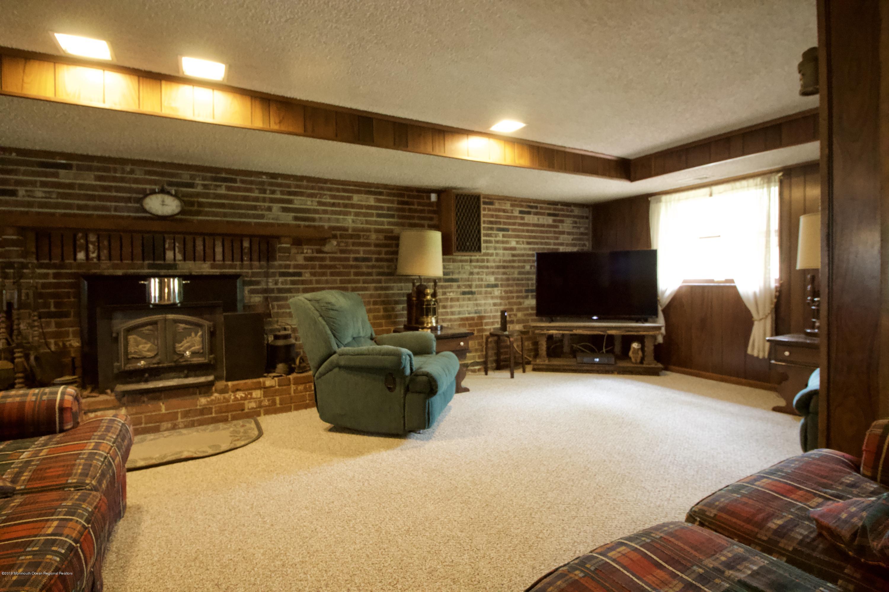 184 Old Tavern Road Farmingdale, NJ 07727 - Photo 21 of 39 a living room with furniture a flat screen tv and a fireplace
