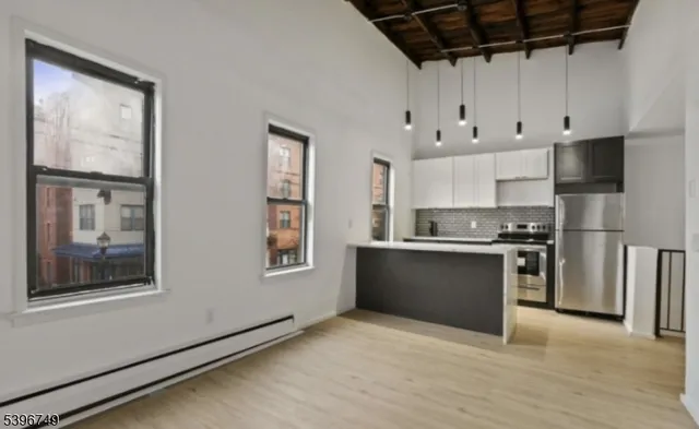 a large kitchen with stainless steel appliances granite countertop a stove a sink and a refrigerator