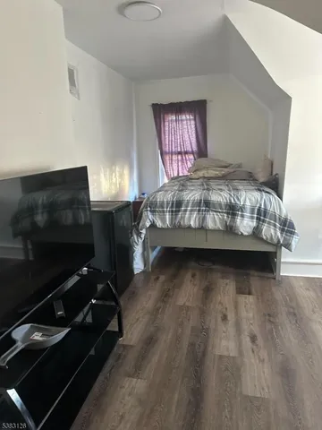 a bedroom with a bed next to a window with tv