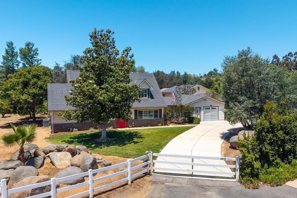 2430 Geyer Lane Alpine, CA 91901 - Photo 60 of 60 a view of a white house with a yard plants and a lawn chair under large tree