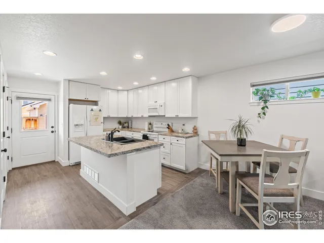 a bathroom with a granite countertop sink a toilet a shower curtain and a bath tub
