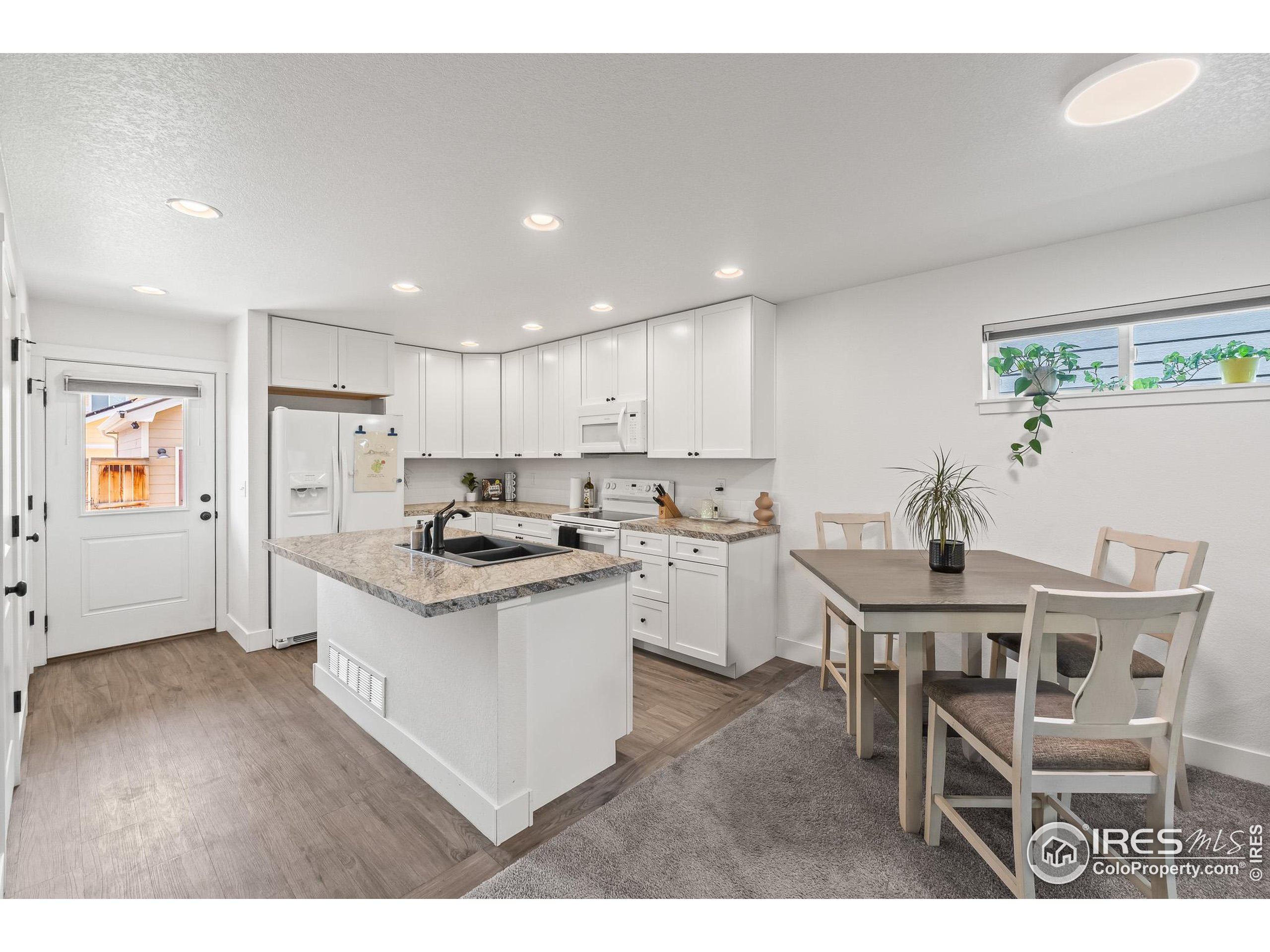 2771 Red Wheat Trail Berthoud, CO 80513 - Photo 16 of 46 a kitchen with stainless steel appliances granite countertop a white cabinets and wooden floor