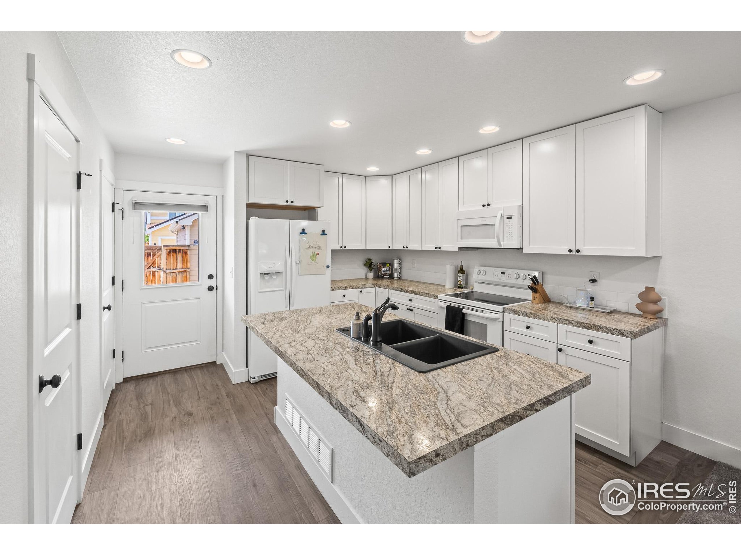 2771 Red Wheat Trail Berthoud, CO 80513 - Photo 19 of 46 a kitchen with stainless steel appliances granite countertop a sink stove and refrigerator