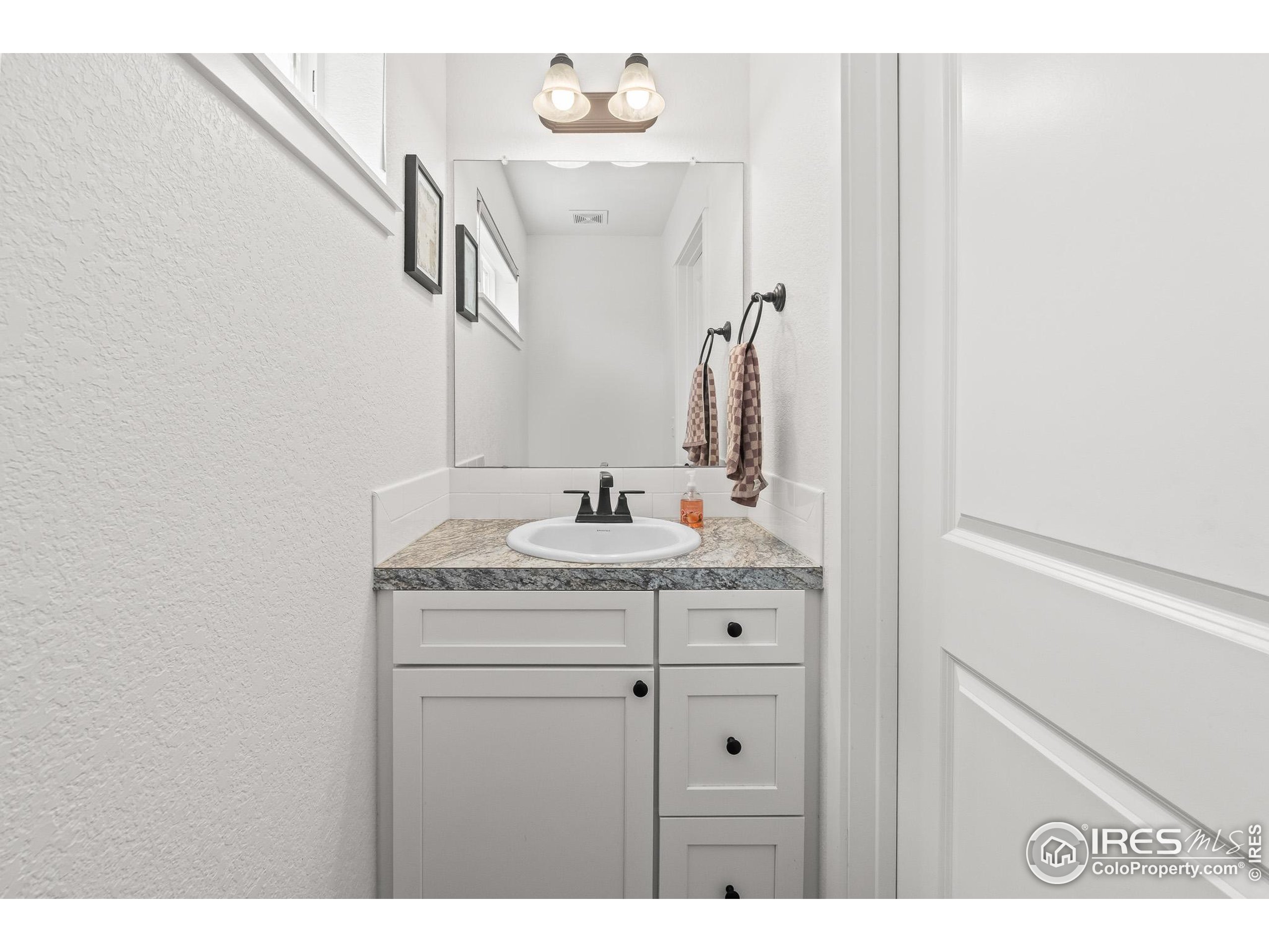 2771 Red Wheat Trail Berthoud, CO 80513 - Photo 24 of 46 a bathroom with a granite countertop sink and a mirror