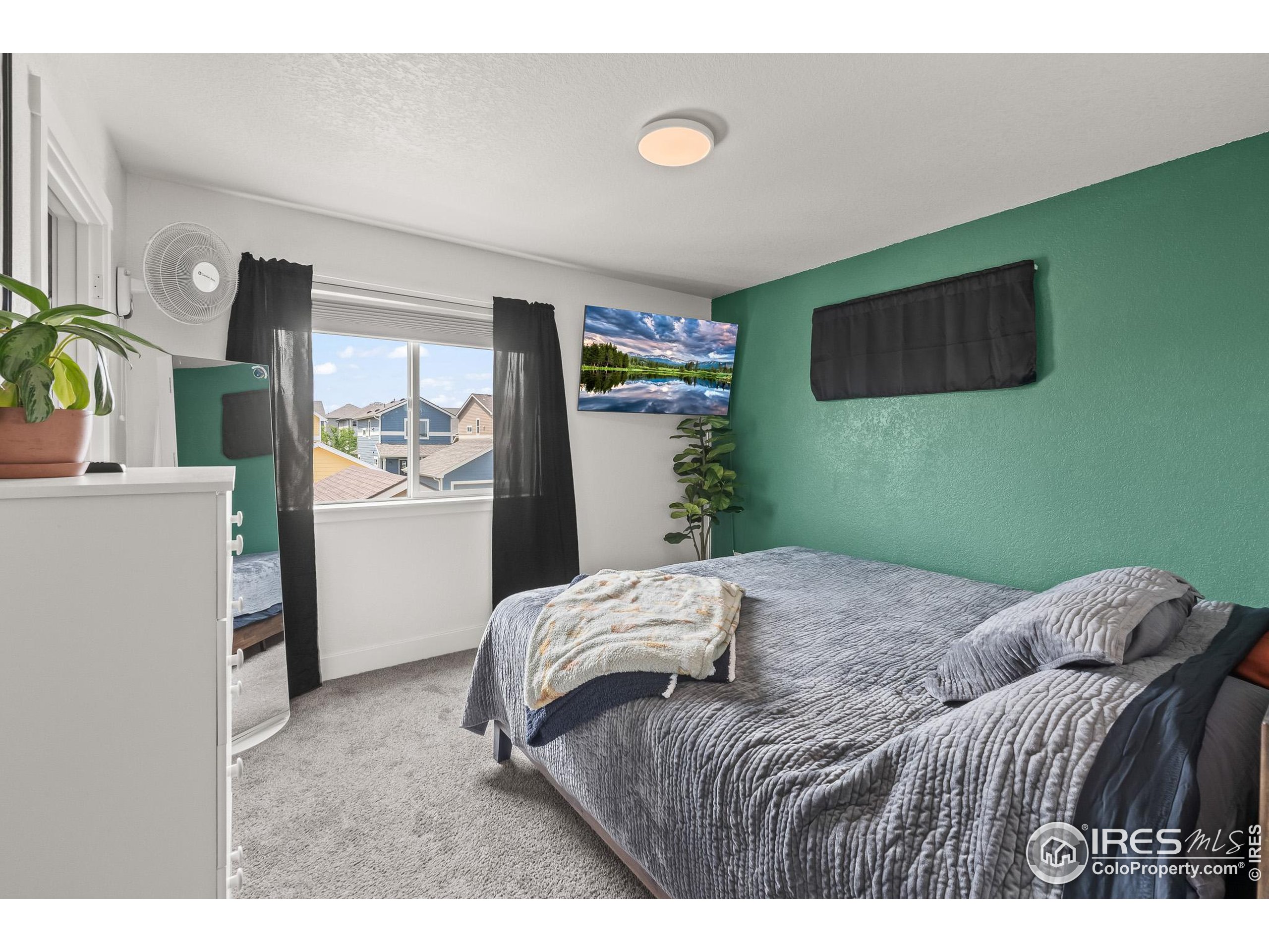 2771 Red Wheat Trail Berthoud, CO 80513 - Photo 30 of 46 a bedroom with a bed and a flat screen tv