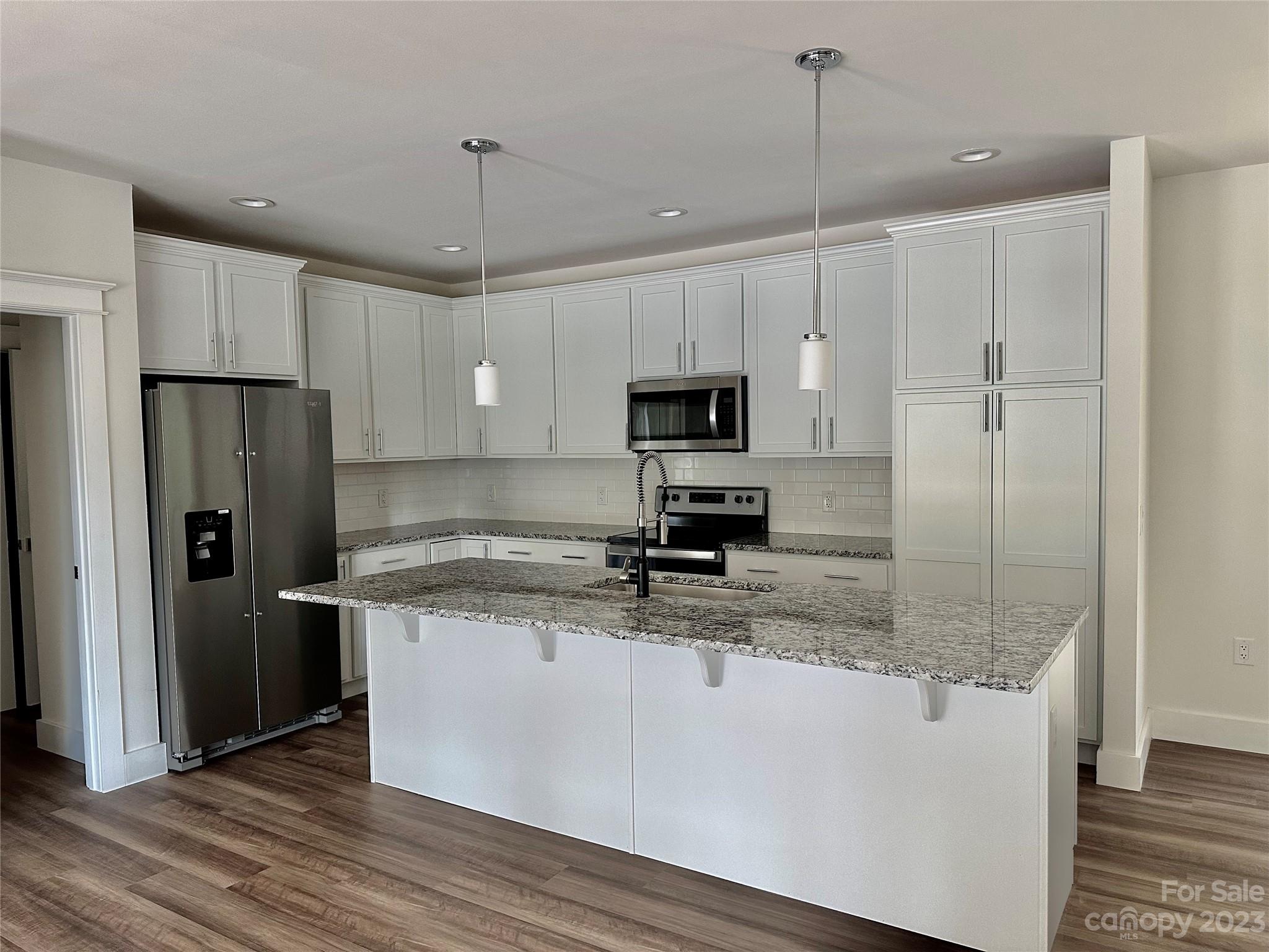 170 Cascade Rdg Road Fairview, NC 28730 - Photo 7 of 23 a kitchen with kitchen island granite countertop a refrigerator a sink and a stove