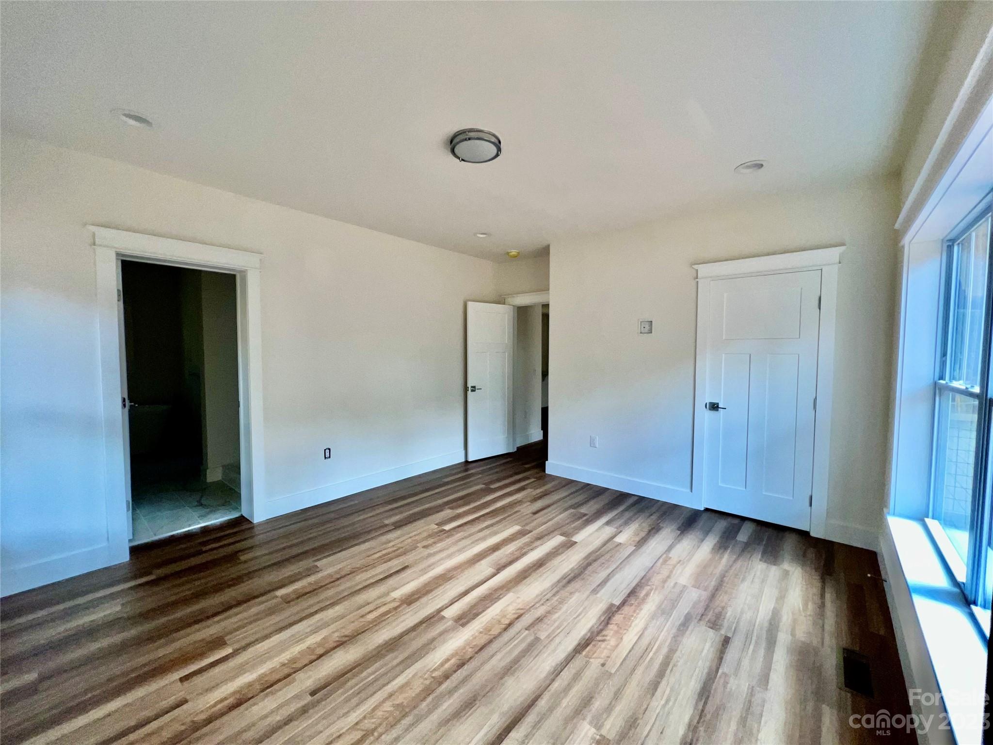 170 Cascade Rdg Road Fairview, NC 28730 - Photo 10 of 23 a view of an empty room with wooden floor and a window