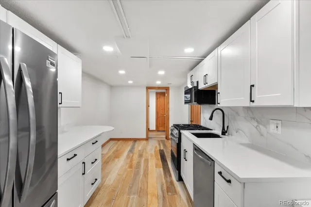 a kitchen with stainless steel appliances granite countertop a sink refrigerator and cabinets