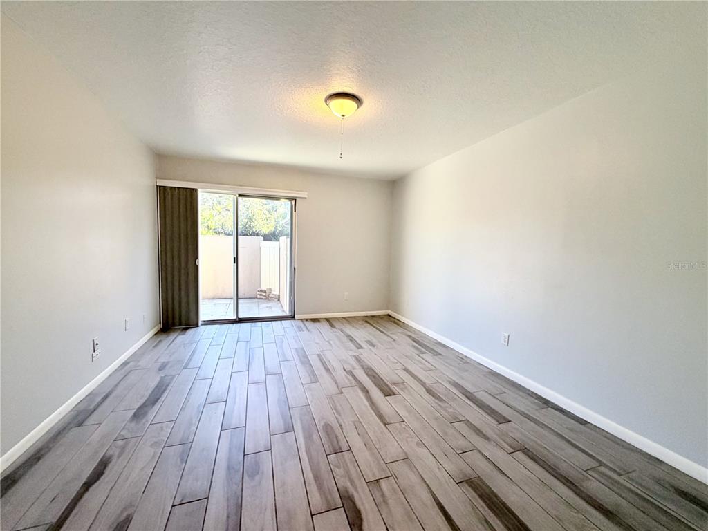 2284 Oak Neck Road, Unit F Clearwater, FL 33763 - Photo 18 of 34 a view of an empty room with wooden floor and a window