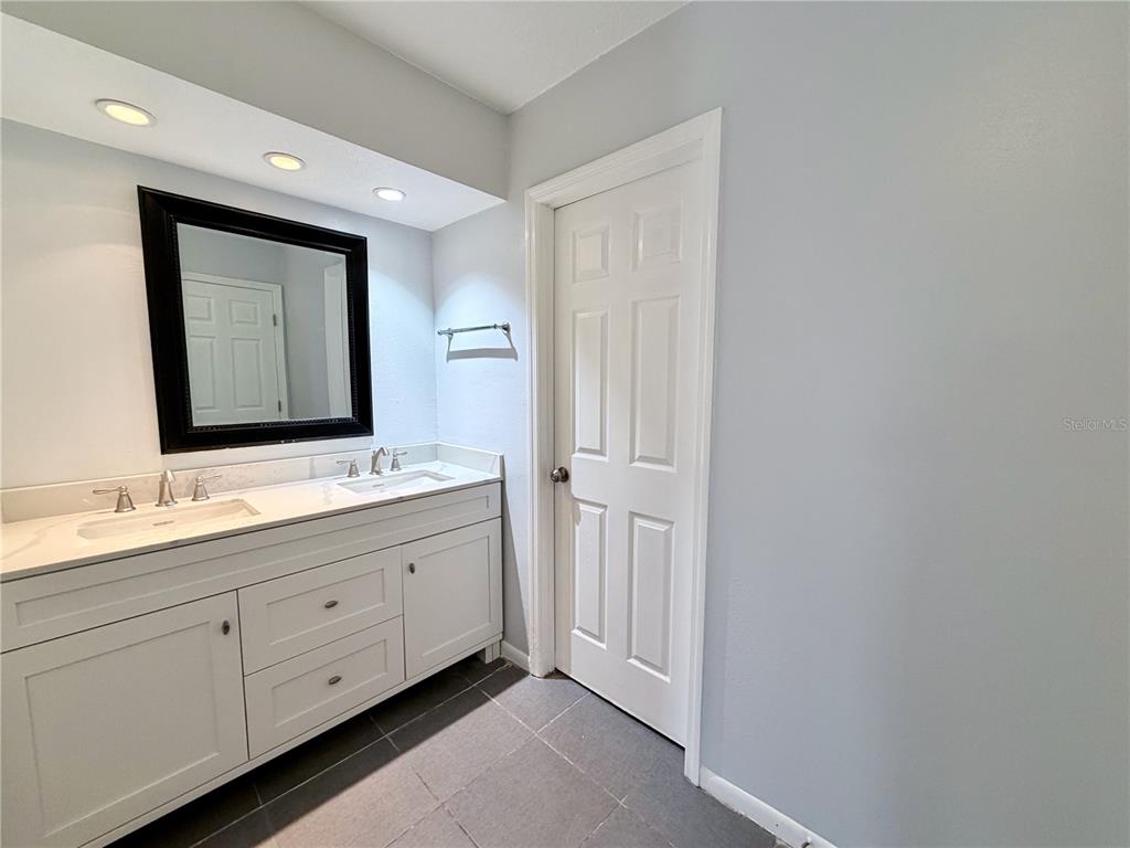 2284 Oak Neck Road, Unit F Clearwater, FL 33763 - Photo 22 of 34 a bathroom with a double vanity sink and a mirror