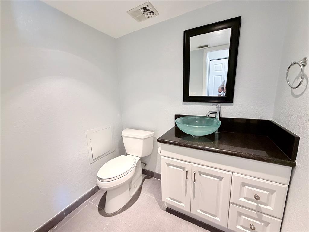 2284 Oak Neck Road, Unit F Clearwater, FL 33763 - Photo 26 of 34 a bathroom with a toilet a sink and mirror