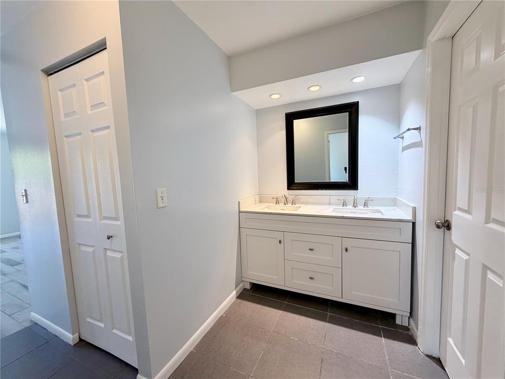 2284 Oak Neck Road, Unit F Clearwater, FL 33763 - Photo 29 of 34 a bathroom with a double vanity sink and mirror