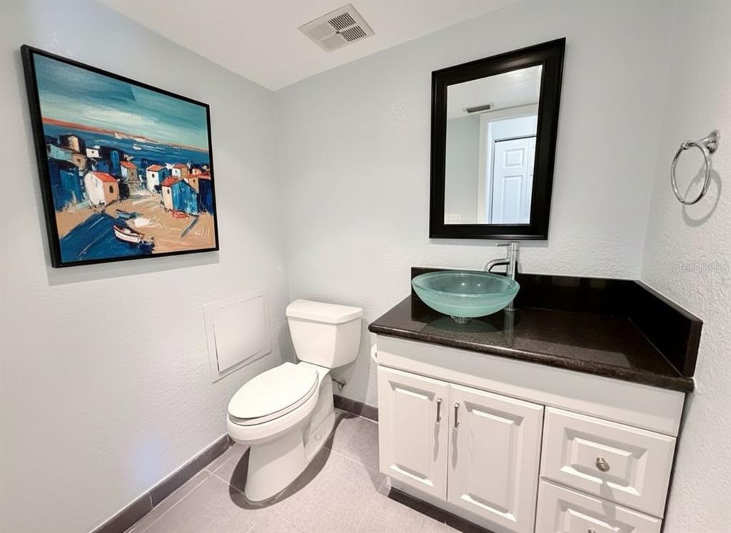 2284 Oak Neck Road, Unit F Clearwater, FL 33763 - Photo 32 of 34 a bathroom with a toilet a sink and mirror
