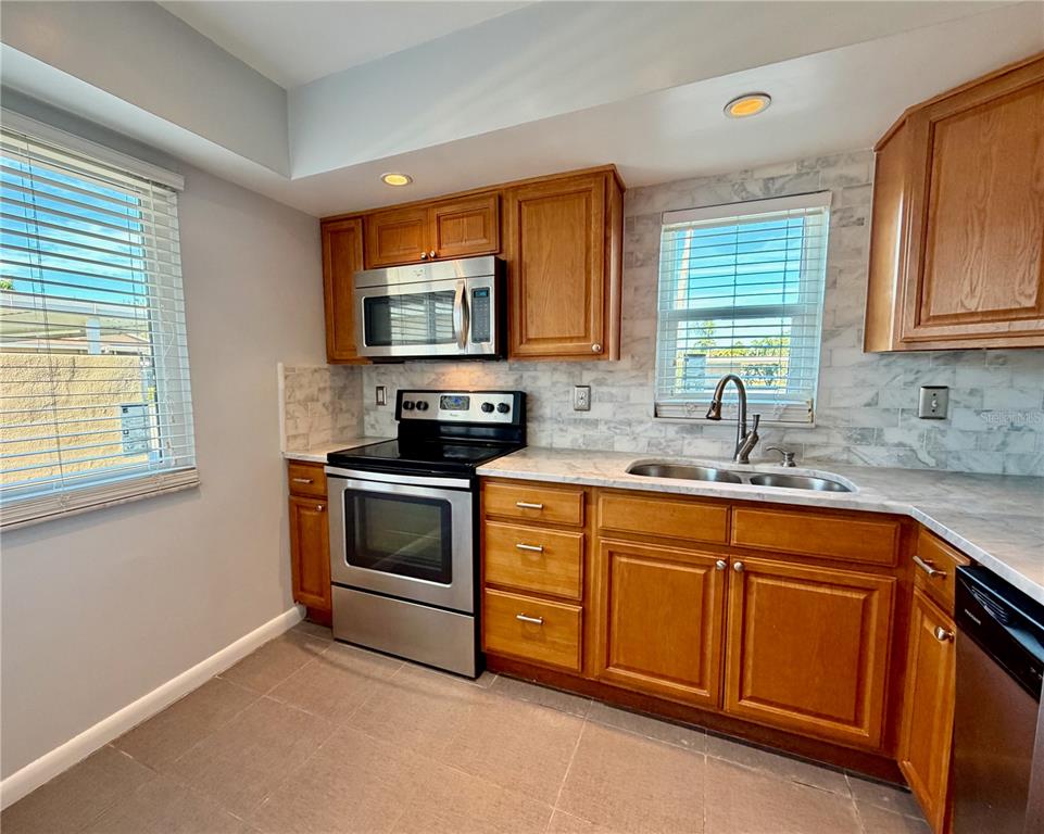 2284 Oak Neck Road, Unit F Clearwater, FL 33763 - Photo 9 of 34 a kitchen with stainless steel appliances granite countertop a stove microwave and sink