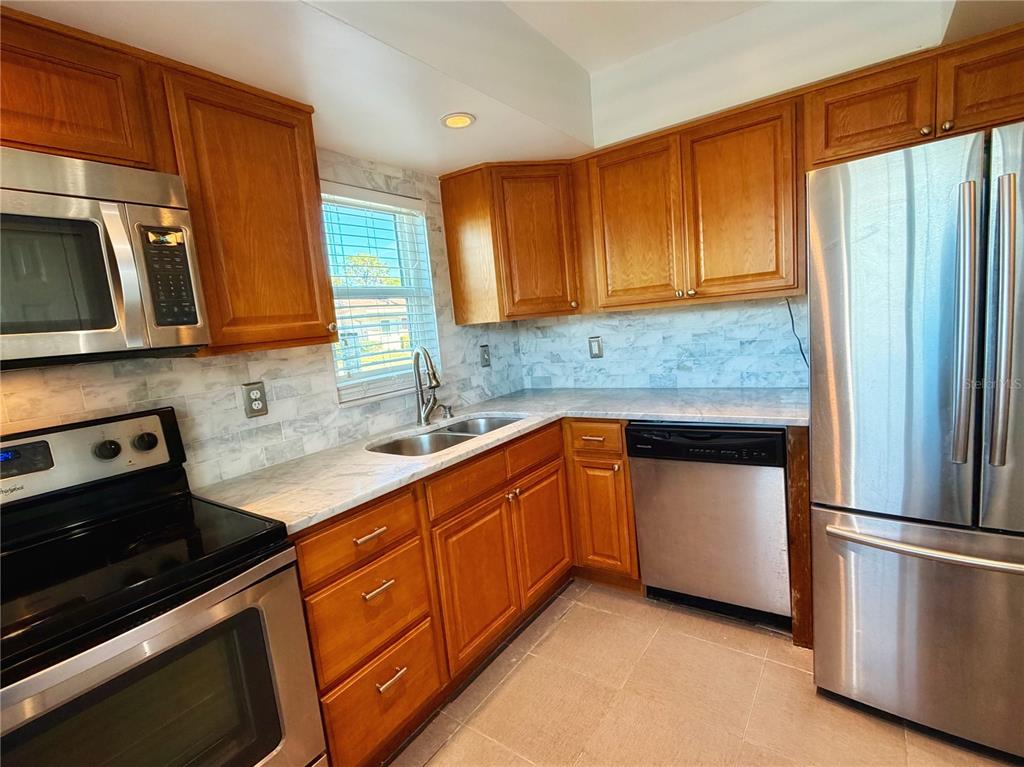 2284 Oak Neck Road, Unit F Clearwater, FL 33763 - Photo 10 of 34 a kitchen with stainless steel appliances granite countertop a refrigerator sink and stove