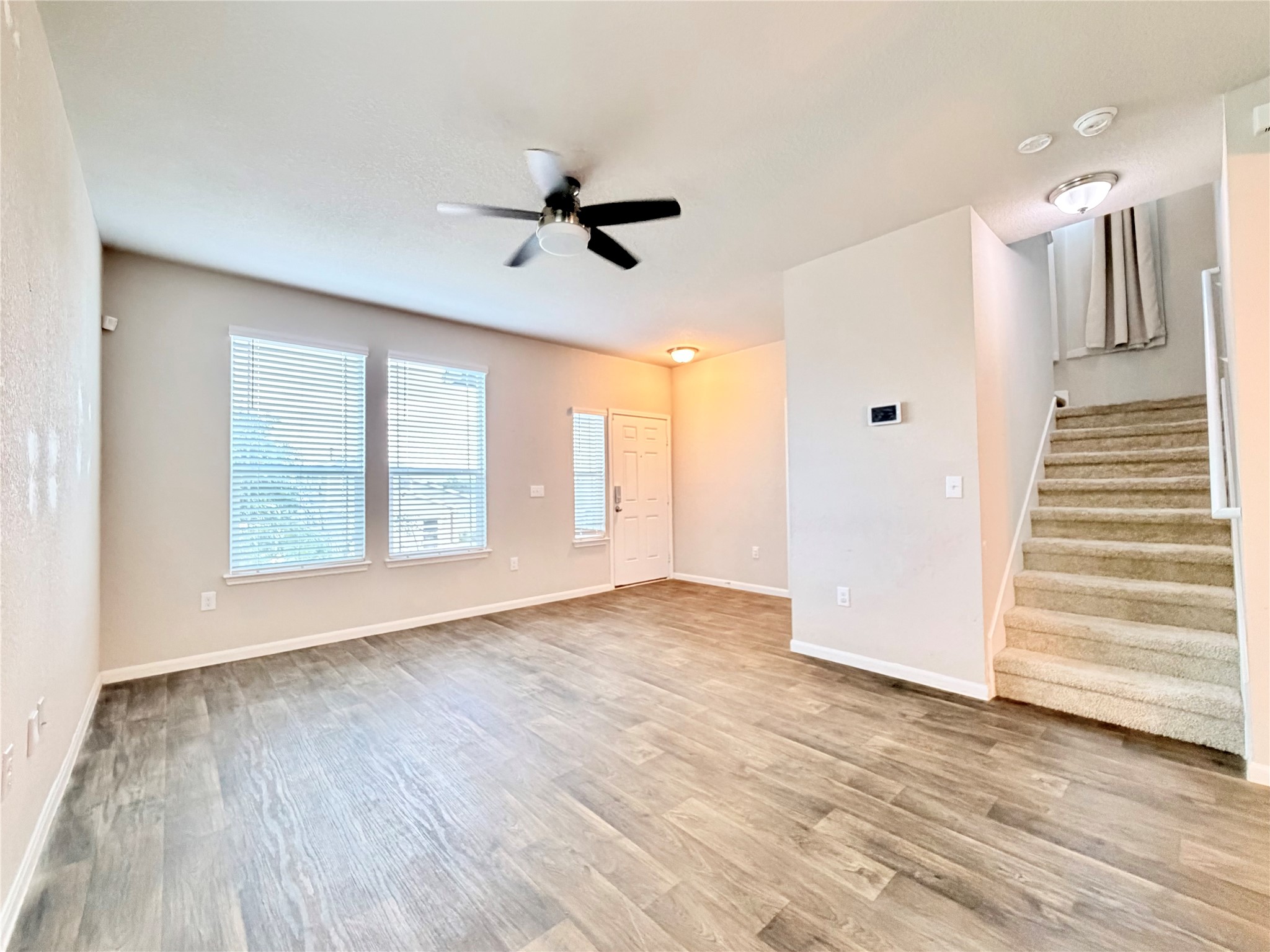 10502 Fulton Avenue Austin, TX 78754 - Photo 5 of 36 A spacious living room featuring resilient wood-look flooring and a functional ceiling fan.
