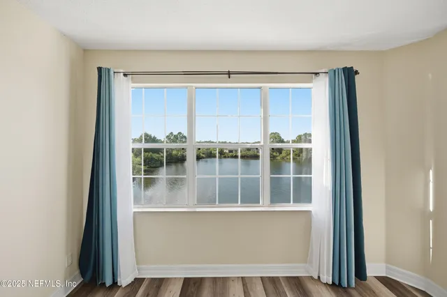 an empty room with windows and fan