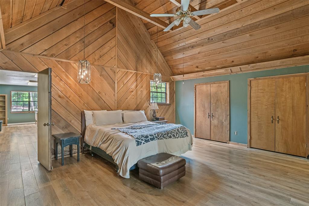 10307 Pirogue Road Oil City, LA 71061 - Photo 18 of 36 a spacious bedroom with a bed and wooden floor