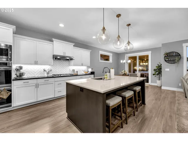 a kitchen with kitchen island granite countertop a sink cabinets and wooden floor