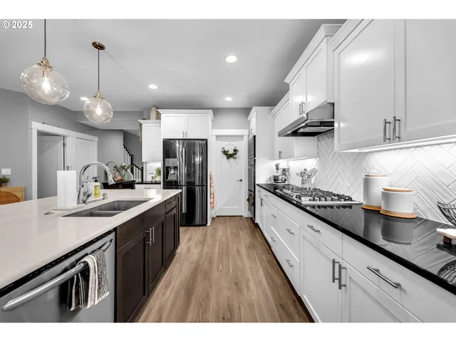 a large kitchen with stainless steel appliances kitchen island a large counter tops a stove a sink and a refrigerator