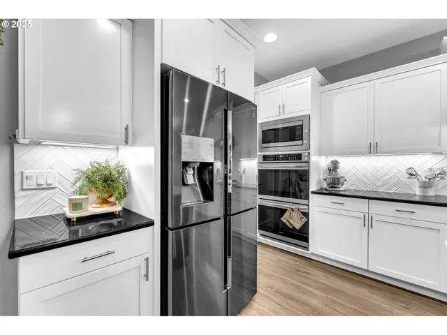 a kitchen with granite countertop a refrigerator and a sink