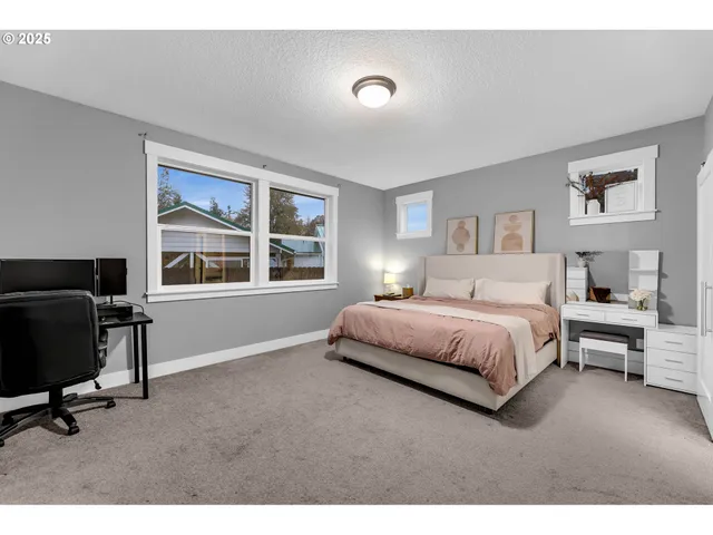 a spacious bedroom with a bed and a chair