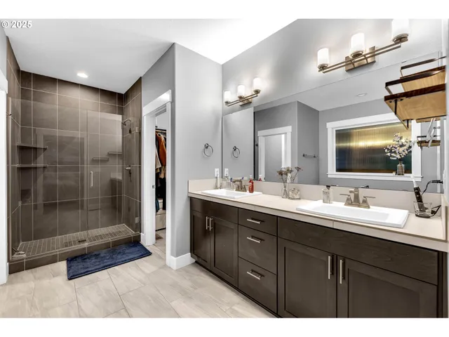 a bathroom with a double vanity sink mirror and shower