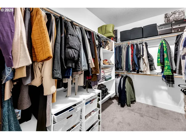 a view of walk in closet with clothes and shoes