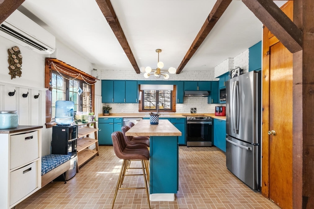 21 Gee Avenue Gloucester, MA 01930 - Photo 19 of 35 a kitchen with stainless steel appliances granite countertop a refrigerator a sink dishwasher a stove and a dining table with wooden floor
