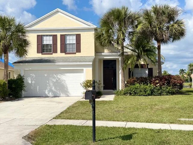 a front view of a house with a yard and trees