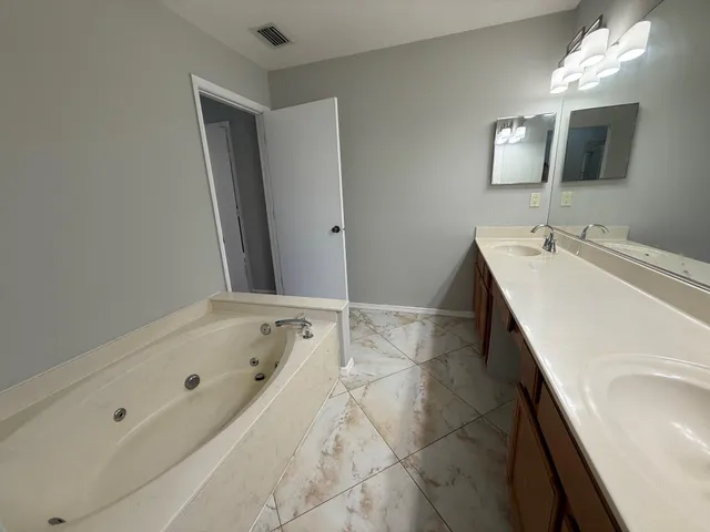 a bathroom with a tub sink and mirror