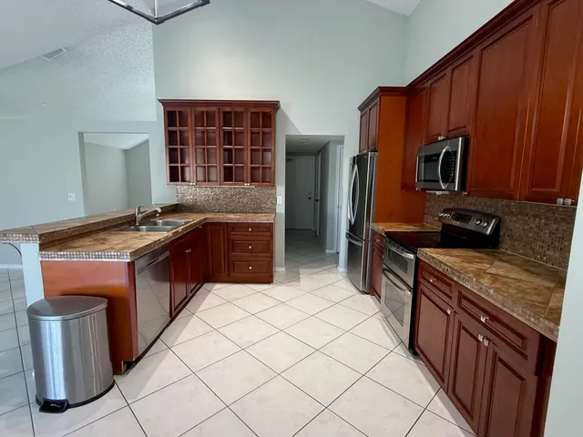a kitchen with stainless steel appliances granite countertop a stove a sink and a microwave