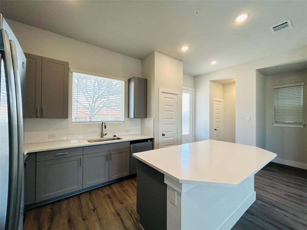 760 West Bedford Euless Road, Unit 214 Hurst, TX 76053 - Photo 13 of 32 a kitchen with a sink a refrigerator and wooden floor
