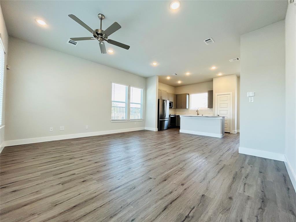 760 West Bedford Euless Road, Unit 214 Hurst, TX 76053 - Photo 23 of 32 a view of an empty room with wooden floor and a kitchen